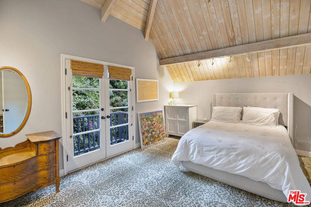 2962 Valmere Drive Malibu, CA 90265 - Photo 39 of 50 a bedroom with a bed a bookshelf and a large window