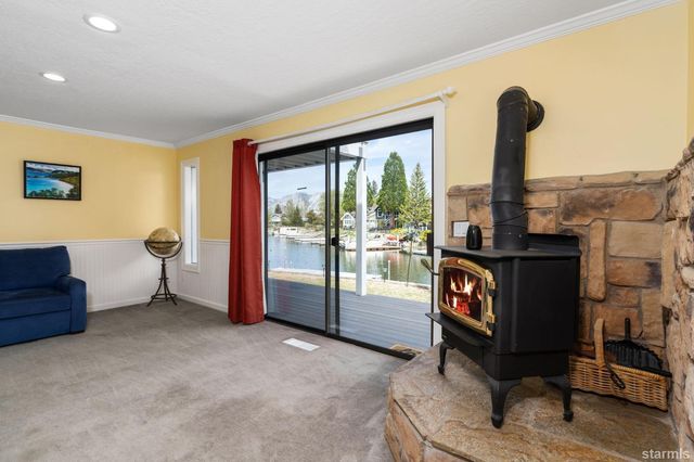 a living room with furniture a floor to ceiling window and potted plant