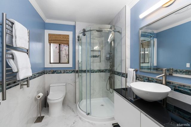 a bathroom with a granite countertop sink toilet and shower