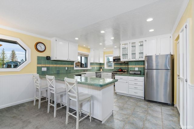 a kitchen with stainless steel appliances granite countertop a refrigerator and a stove top oven