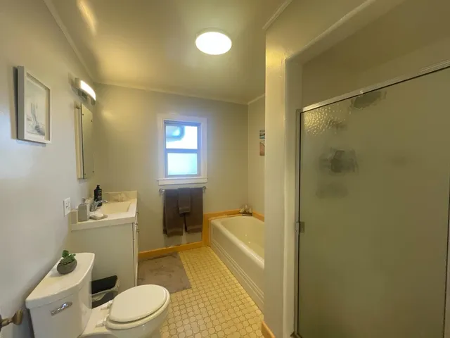 a bathroom with a sink a toilet and shower