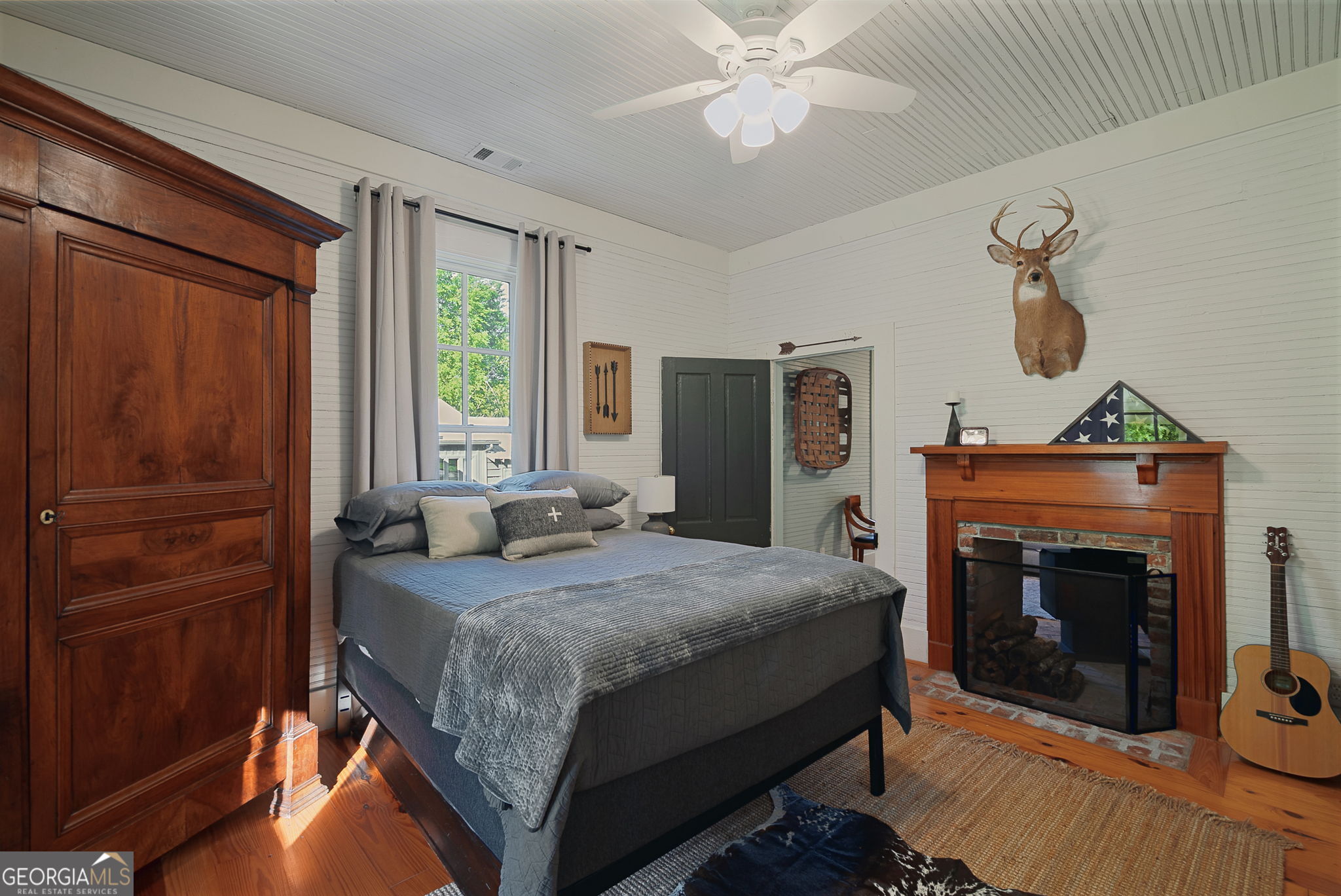 235 Glades Road Eatonton, GA 31024 - Photo 36 of 79 a bedroom with a bed and a fireplace