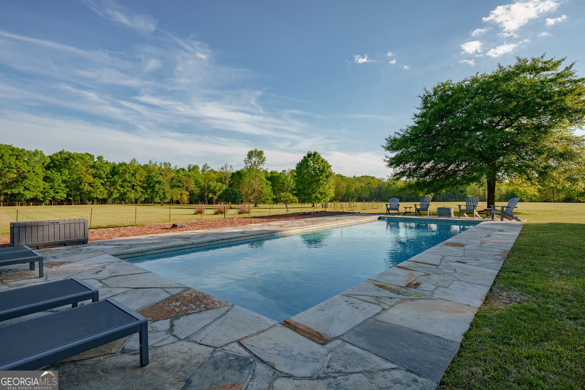 235 Glades Road Eatonton, GA 31024 - Photo 39 of 79 a view of swimming pool with seating area and trees in the background