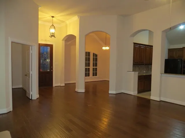 a view of a room with wooden floor and entryway