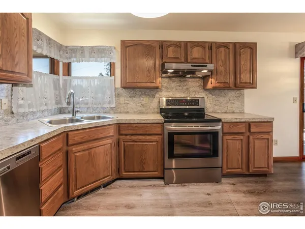 a kitchen with kitchen island granite countertop a sink cabinets and stainless steel appliances