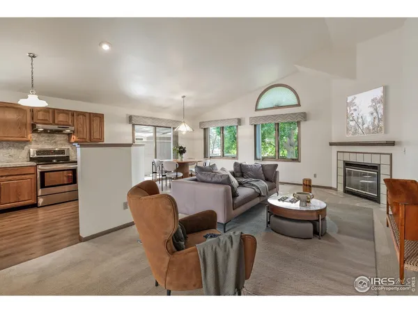 a living room with furniture a fireplace and a kitchen view