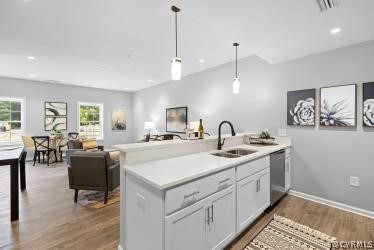a view of center island of a kitchen with a sink a counter space appliances and cabinets