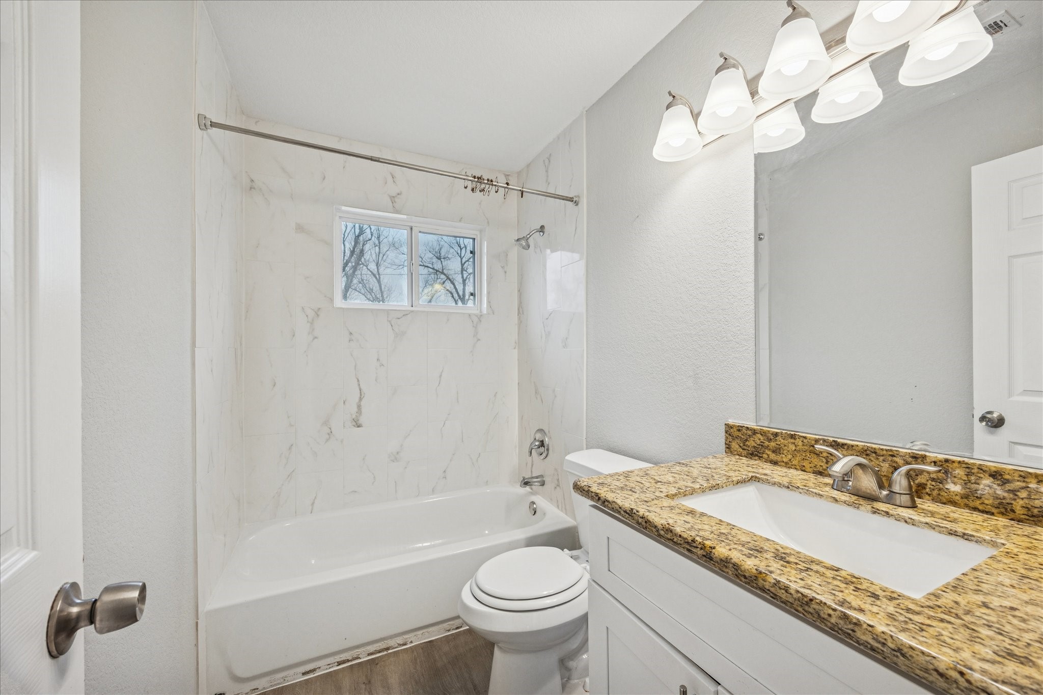 5126 Higgins Street Houston, TX 77033 - Photo 11 of 14 a bathroom with a granite countertop sink a toilet and a bathtub