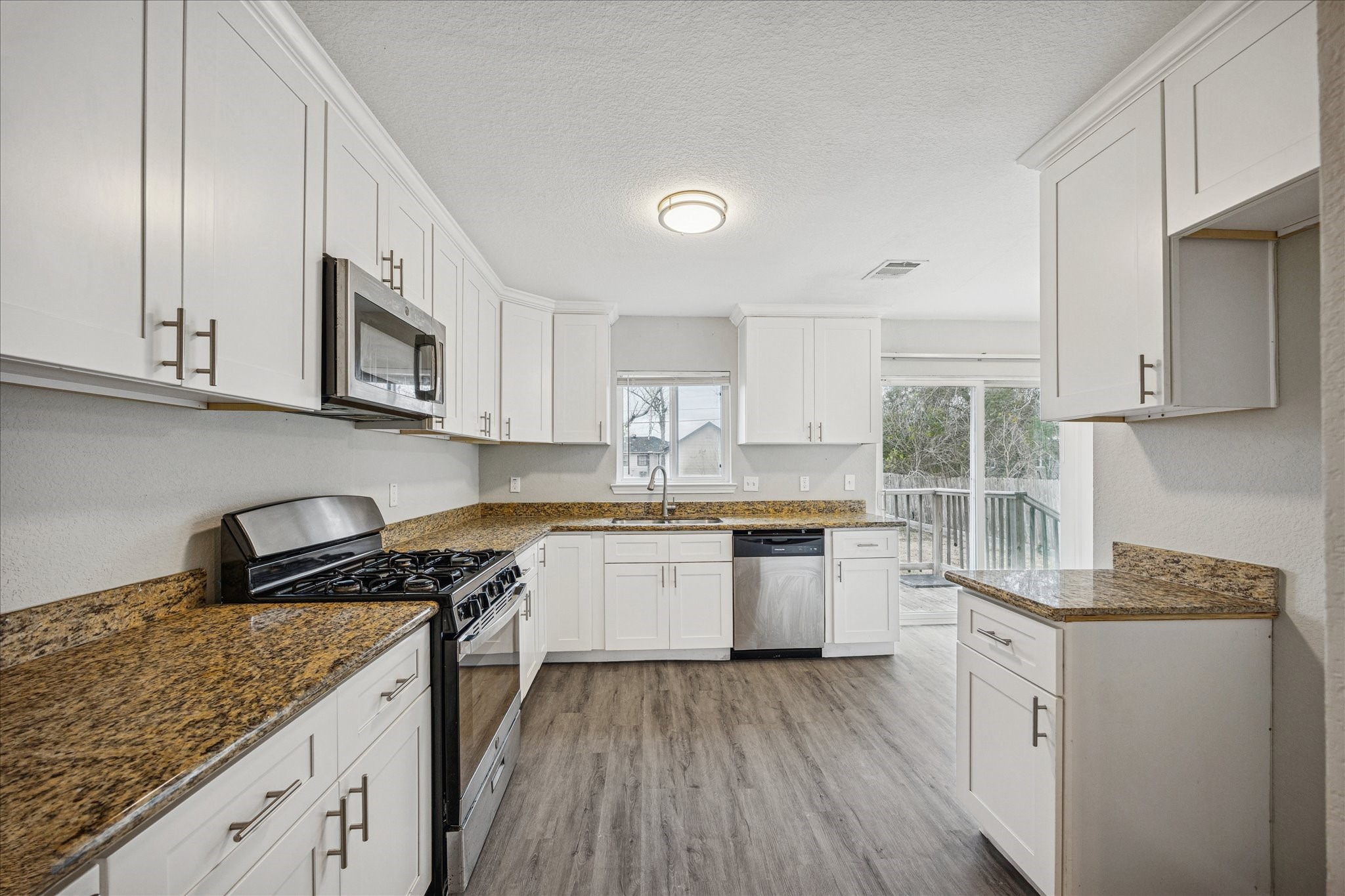 5126 Higgins Street Houston, TX 77033 - Photo 3 of 14 a kitchen with stainless steel appliances granite countertop wooden cabinets stove top oven and sink