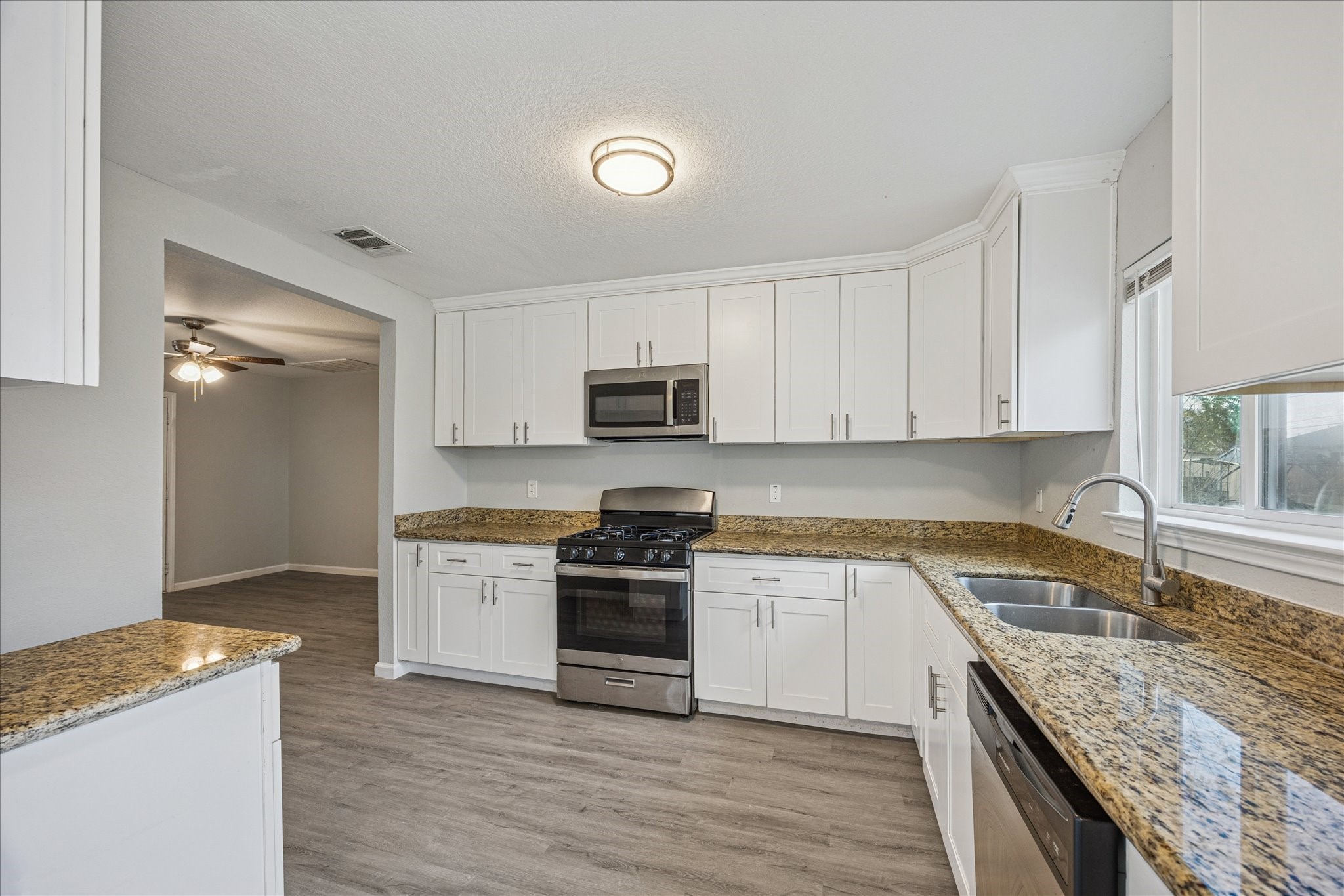 5126 Higgins Street Houston, TX 77033 - Photo 7 of 14 a kitchen with granite countertop a sink a stove top oven and cabinetry