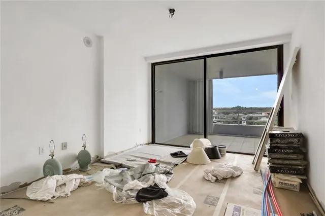 a bedroom with furniture and a large window