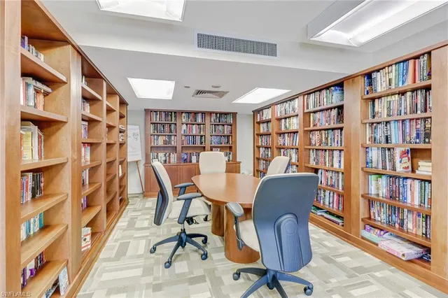 a view of a workspace with furniture and a bookshelf