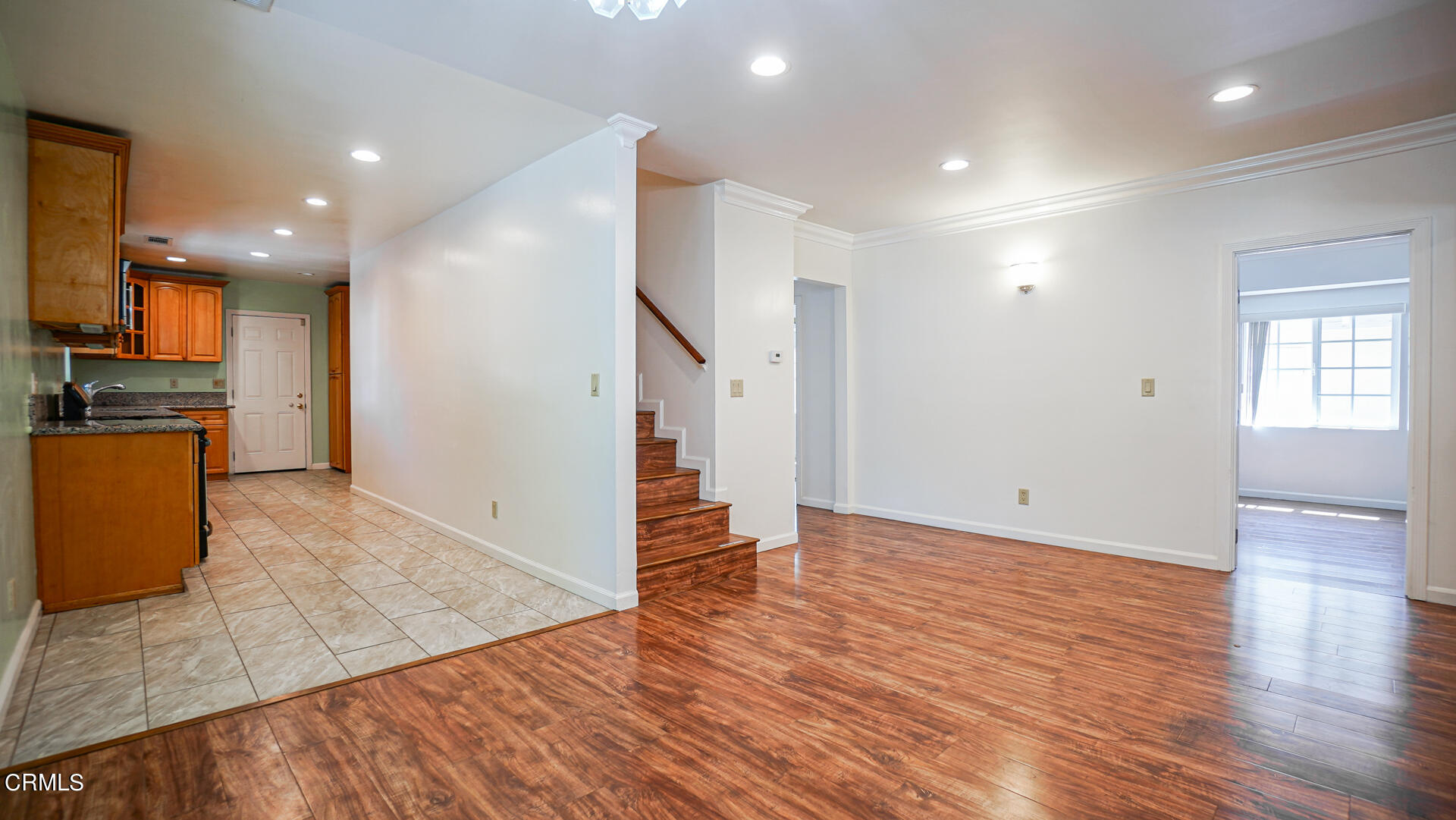 3821 Elma Road Pasadena, CA 91107 - Photo 6 of 27 an empty room with wooden floor and a kitchen