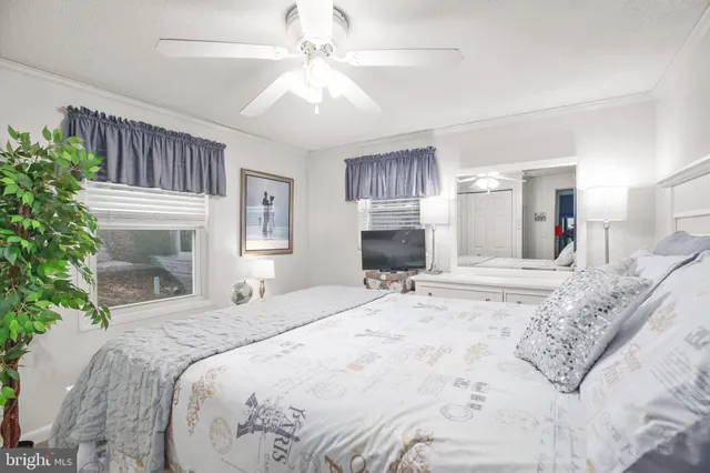 a spacious bedroom with a large bed a chandelier and a mirror