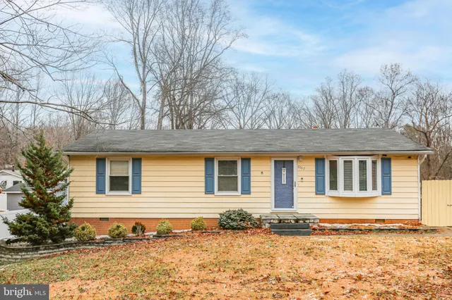 a front view of a house with a yard covered with snow