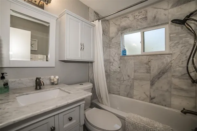 a en suite bathroom with a granite countertop sink and a mirror
