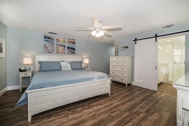 a spacious bedroom with a bed and a dresser