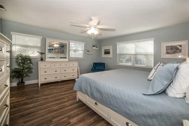 a bathroom with a granite countertop sink toilet a large mirror a shower and a window