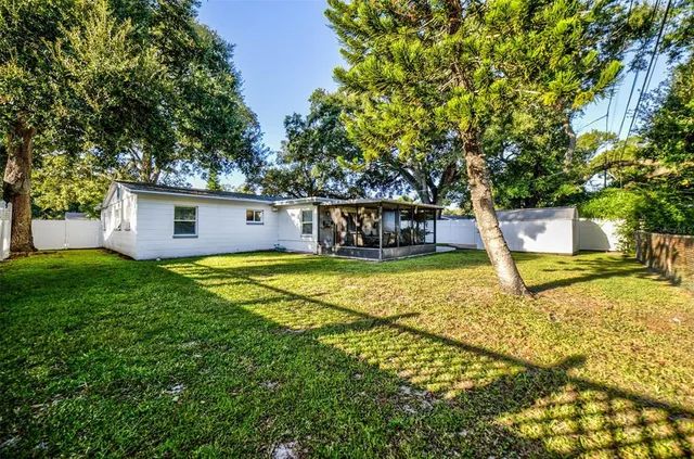 a view of house with a garden and swimming pool