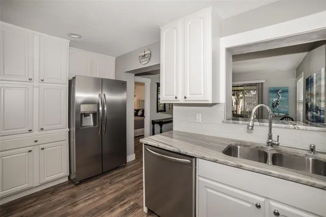 a kitchen with stainless steel appliances kitchen island a refrigerator sink and cabinets