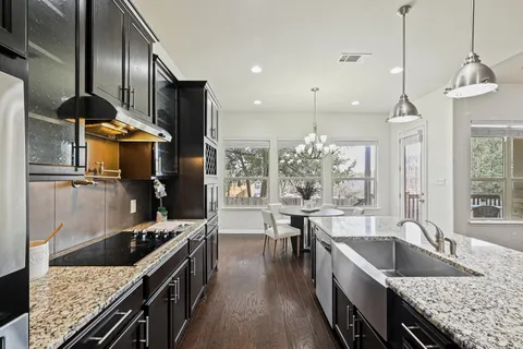a kitchen with stainless steel appliances granite countertop a sink stove and refrigerator
