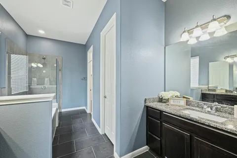 a bathroom with a granite countertop sink a large mirror and a shower