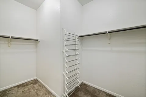 a view of walk in closet with empty racks