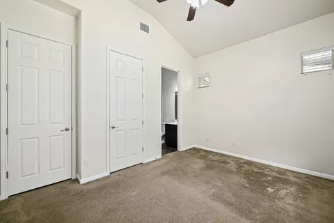 an empty room with fan & windows