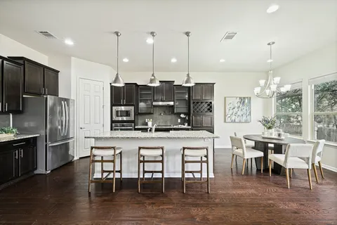 a large kitchen with a table and chairs