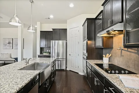 a kitchen with granite countertop a sink stainless steel appliances and cabinets