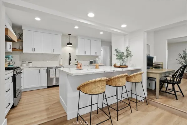 a kitchen with kitchen island a dining table and chairs