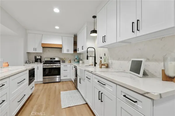 a kitchen with white cabinets appliances and sink