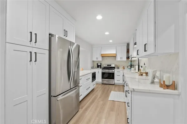 a kitchen with white cabinets and stainless steel appliances