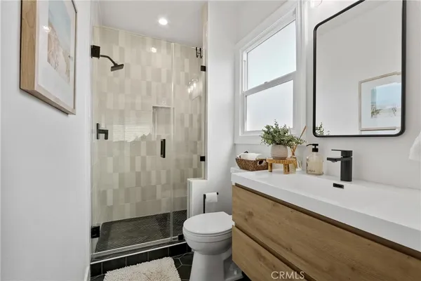 a bathroom with a sink a toilet and shower