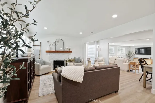 a living room with furniture a fireplace and large windows