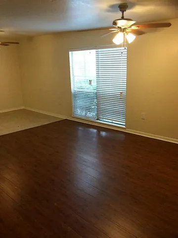 an empty room with wooden floor and entrance