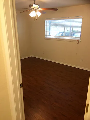 an empty room with wooden floor and mirror