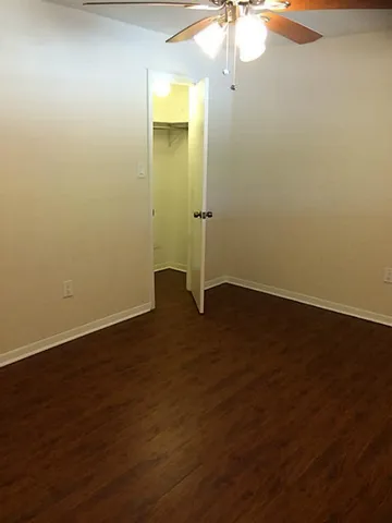 a view of a room with wooden floor and a window