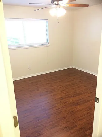 an empty room with wooden floor and door