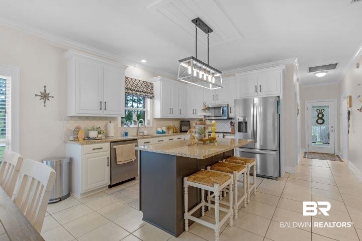 24541 Baldwin Beach Expressway Robertsdale, AL 36567 - Photo 10 of 51 Kitchen with white cabinets, stainless steel appliances, and crown molding