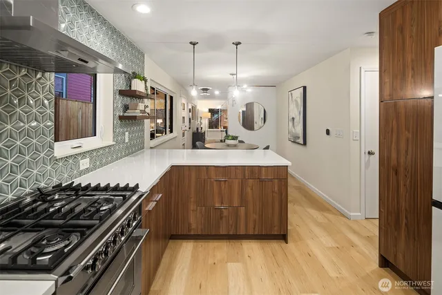 a kitchen with a stove a refrigerator and a wooden floor