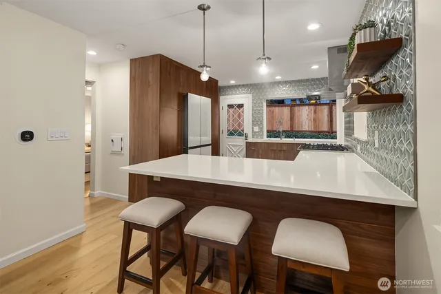 a kitchen with stainless steel appliances granite countertop a kitchen island a table and chairs in it