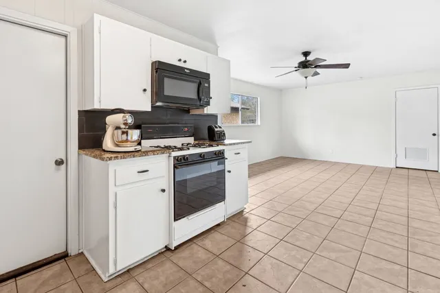 a kitchen with a stove top oven and cabinets