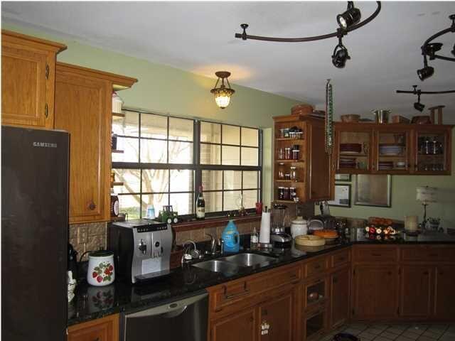 1054 Melton Road Baker, FL 32531 - Photo 23 of 34 a kitchen with sink a refrigerator and wooden cabinets