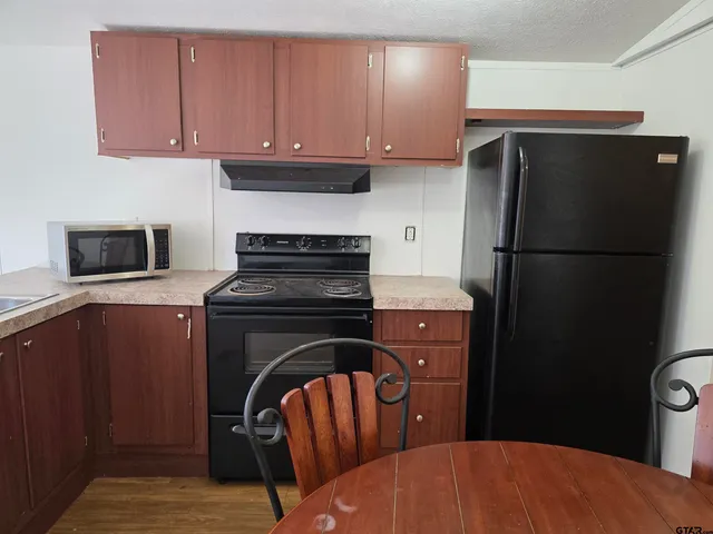 a kitchen with a refrigerator stove and cabinets