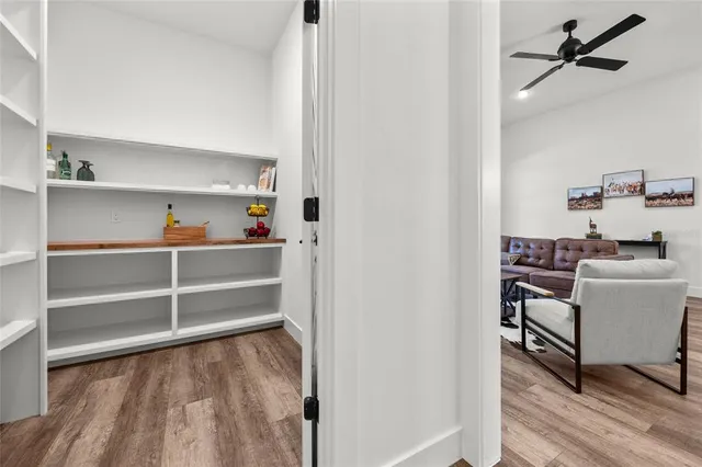 an empty room with wooden floor cabinet and windows