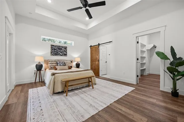 an empty room with wooden floor cabinet and windows