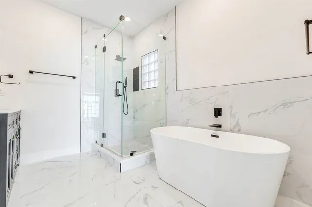 a white bath tub sitting next to a bathroom sink
