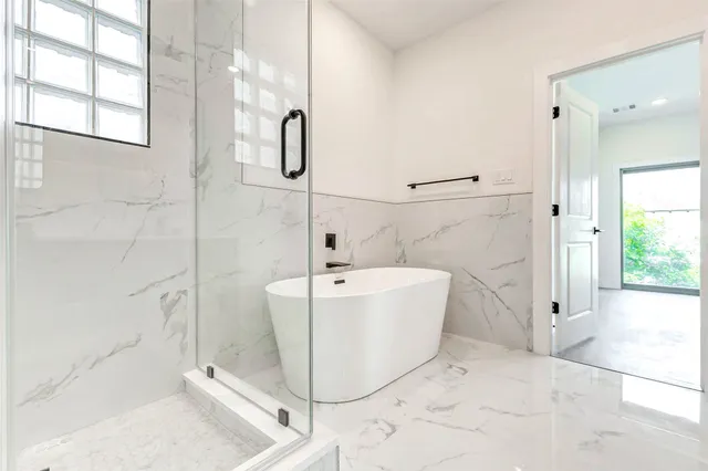 a white bath tub sitting next to a shower