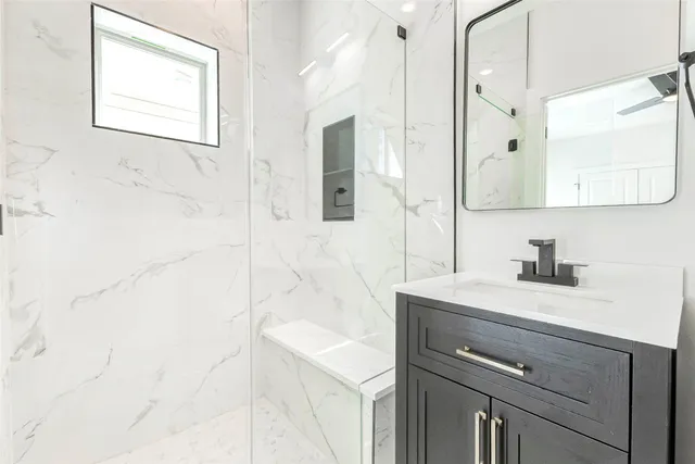 a bathroom with a sink vanity granite and a mirror
